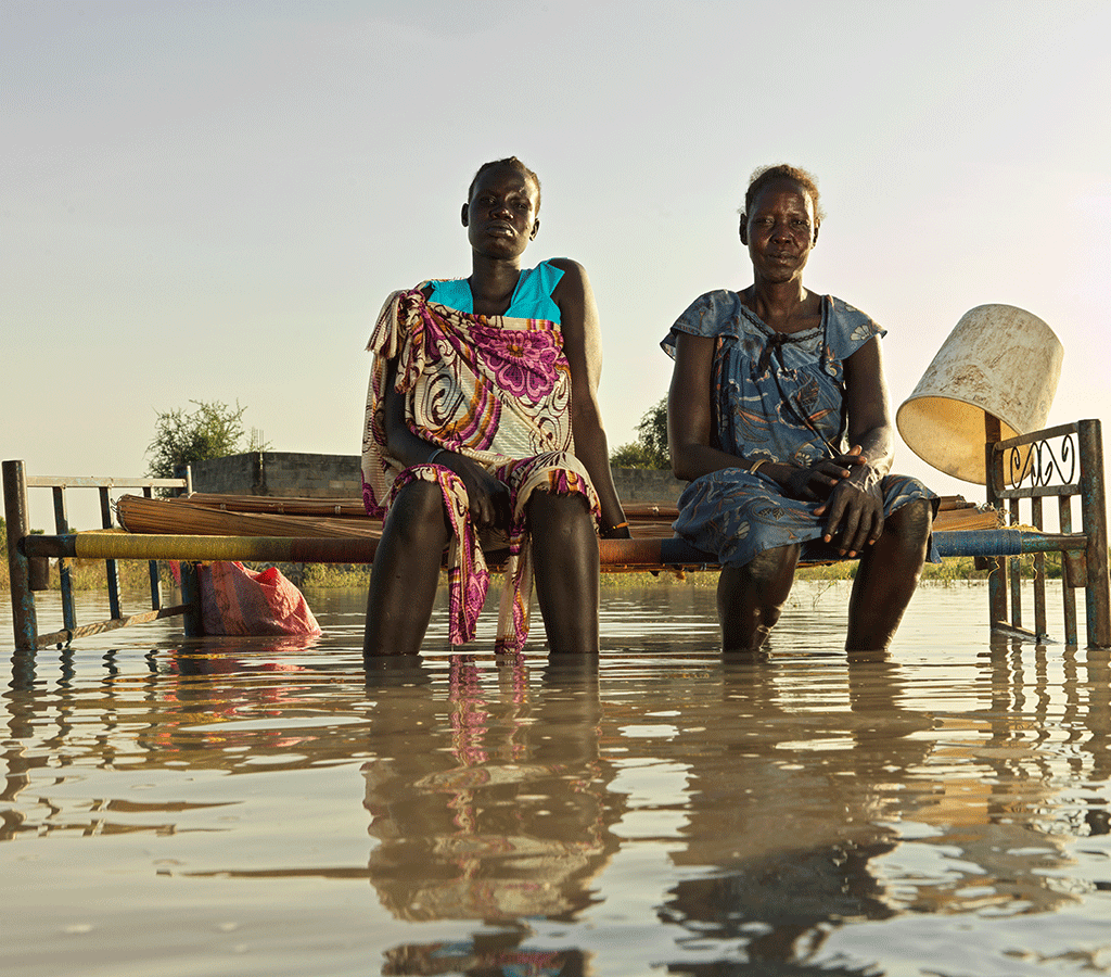 Nyagout Lok, 46, and her pregnant daughter, Nyakoang Majok, 28, set up a bed in the water – there is no room for both of them to sleep inside their temporary shelter.in South Sudan