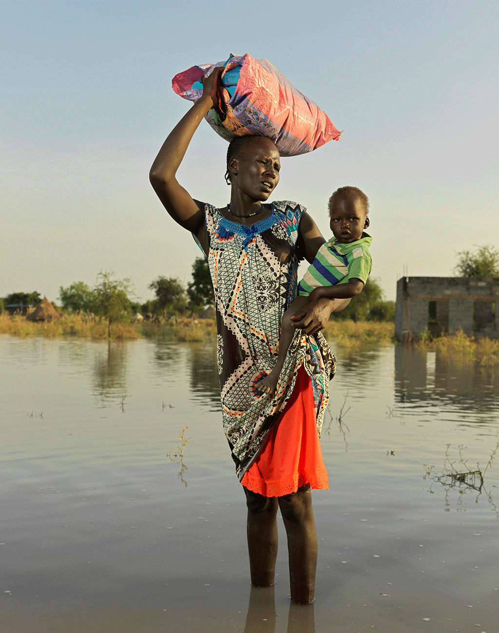 Nyapini Long, 30, heads to find higher ground with all her belongings in South Sudan