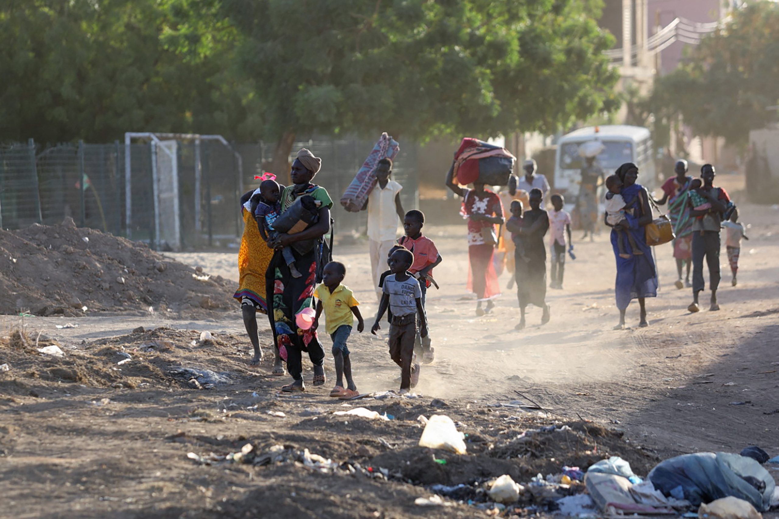 People fleeing their homes on a dirt road in Sudan.