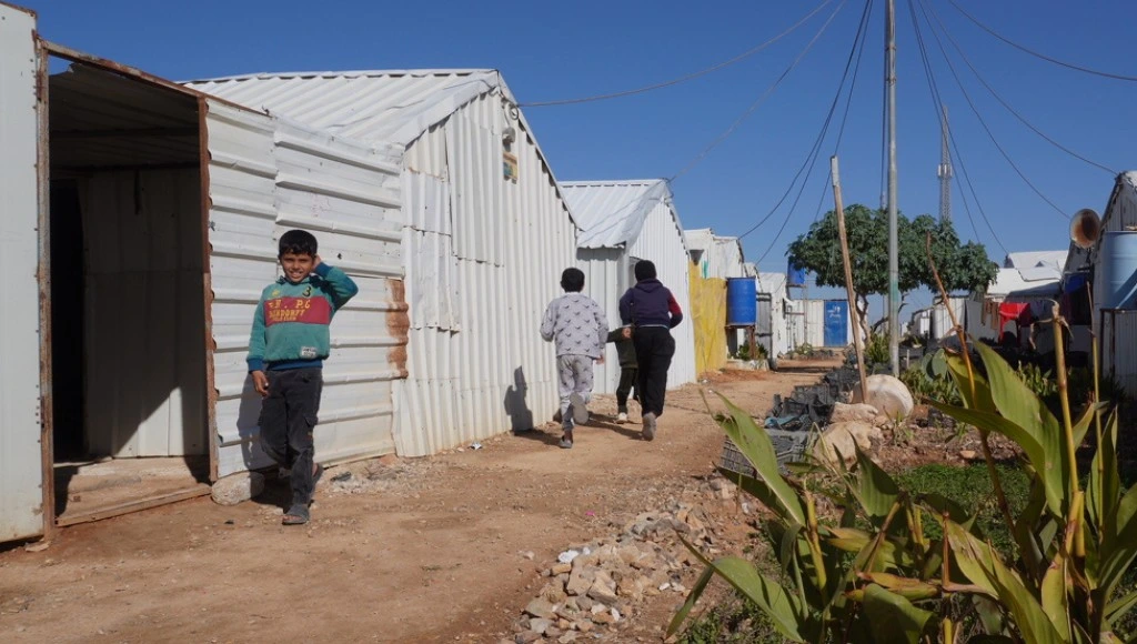 Children walking outside toilets in refugee camp in Somalia.