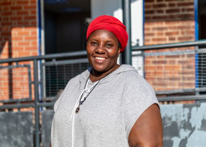 Sistah Stellah, RMUK and Community Hub Lead, standing in front of INI Community and Wellbeing Centre